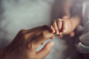 person holdiing baby hand