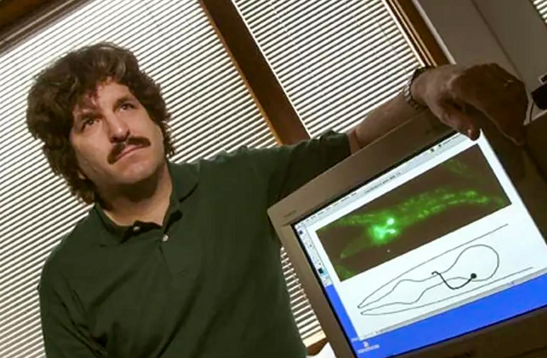 Gary Ruvkun, circa 2000, next to a computer screen showing the roundworm C. elegans.