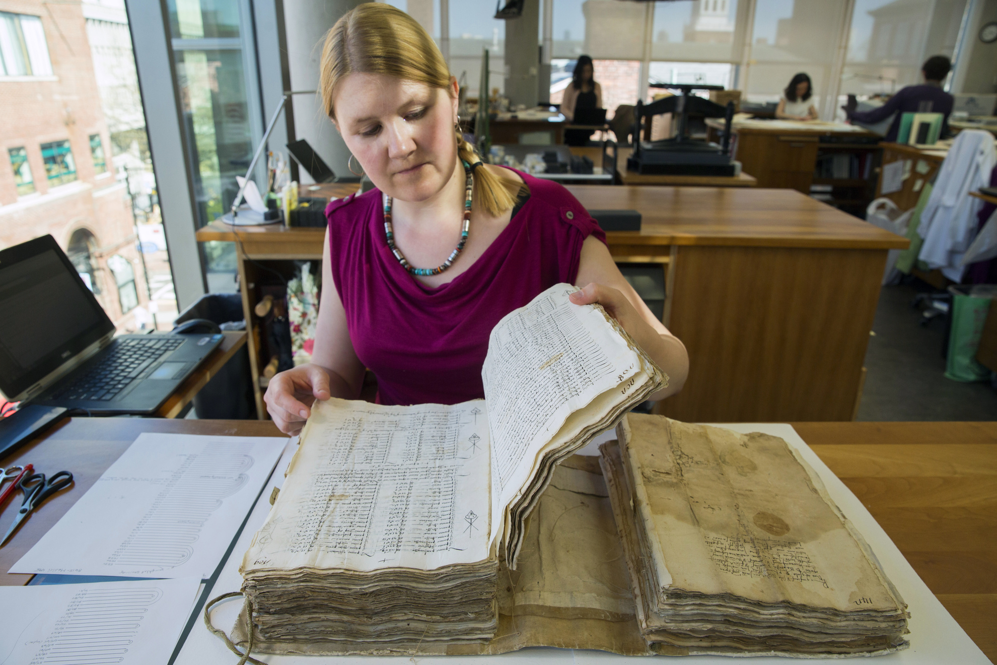 Book Conservator Katherine Beaty works on a bound volume of business records, including partnership agreements and other related documents from Harvard Business School Baker Library.