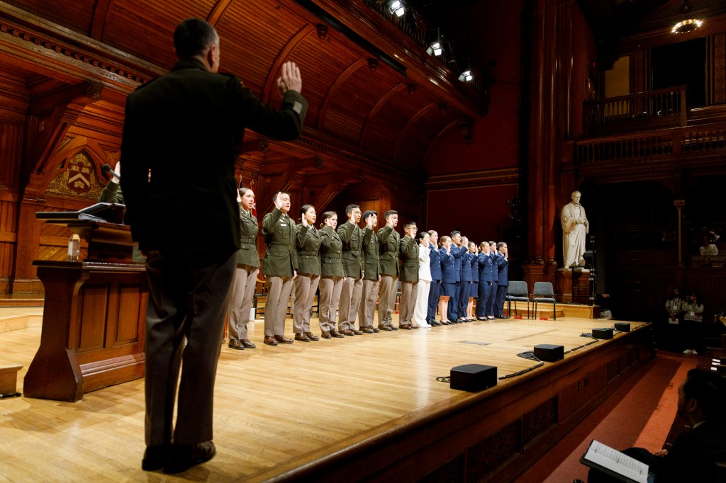 ROTC members take the oath of office during Harvard’s ROTC commissioning ceremony for the Class of 2025, in Sanders Theatre,
