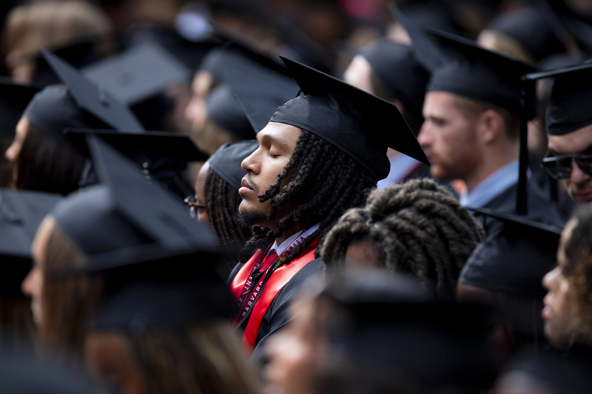 A member of the Class of 2025 closes their eyes as they listen to a valediction for graduating seniors.