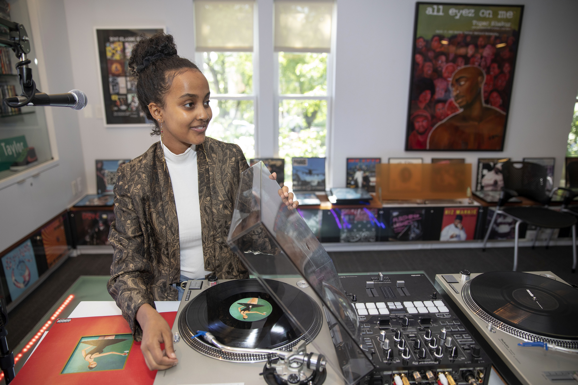 Inside the Hiphop Archive and Research Institute, Makeda Daniel spins a Kanye West record a turn table.