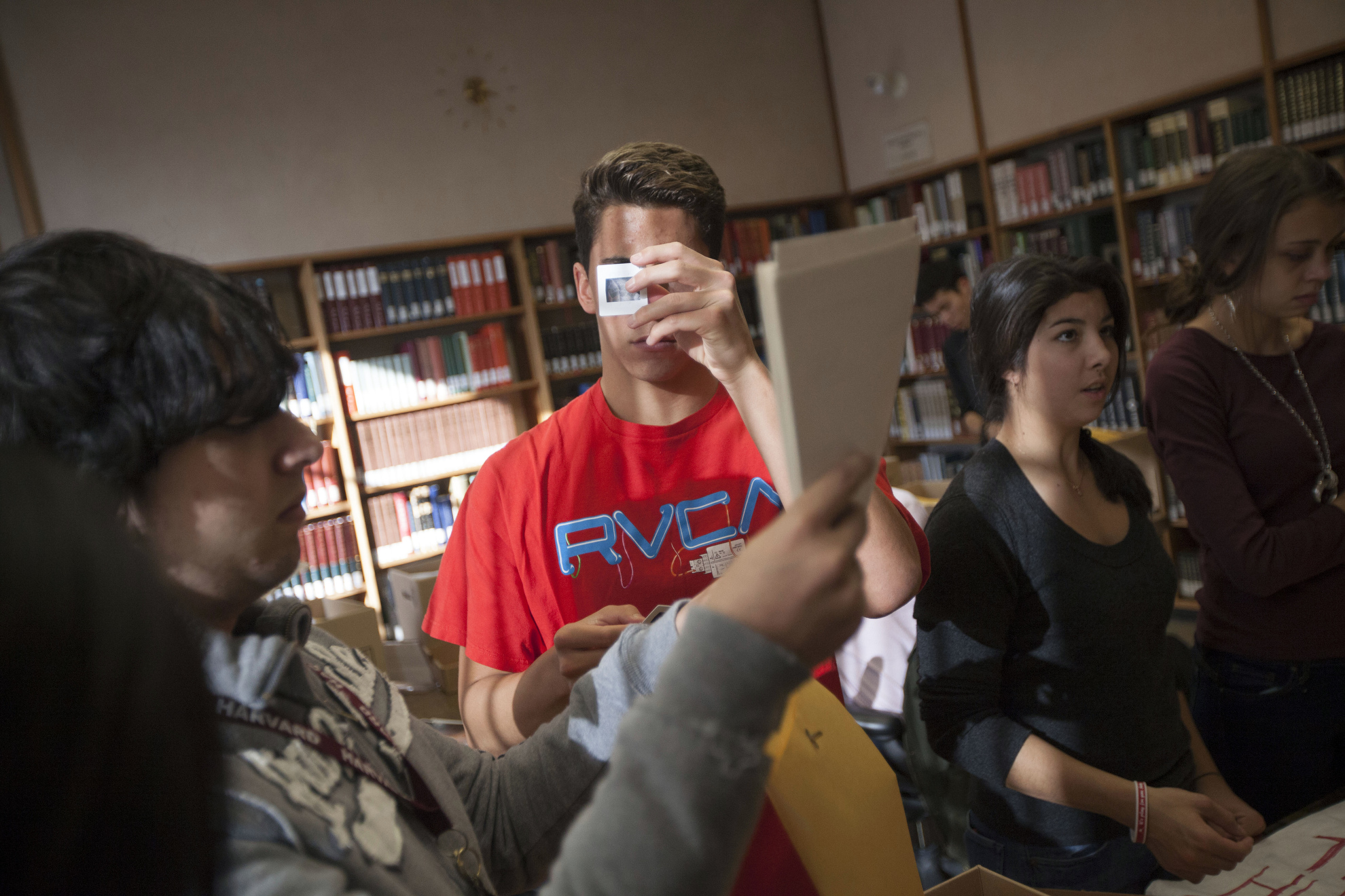 Charles Orta (from left), Blake Lee, Miye D'Oench, and Sarah Fellay look at research materials inside the Harvard-Yenching Library.
