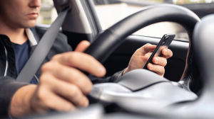 person looking at their phone while driving