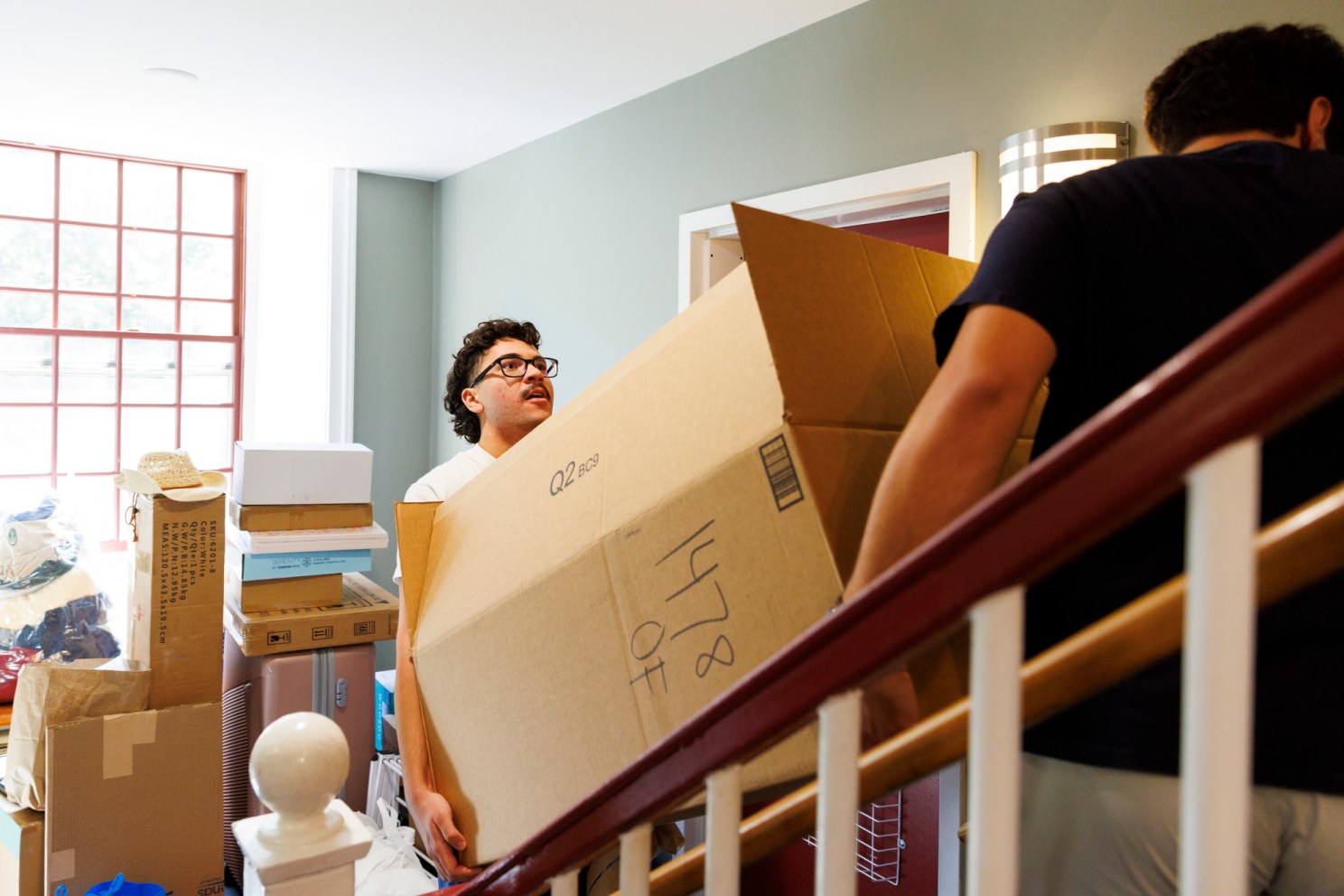 First-year Jose Garcia carries a box up the stairs at Hollis Hall.