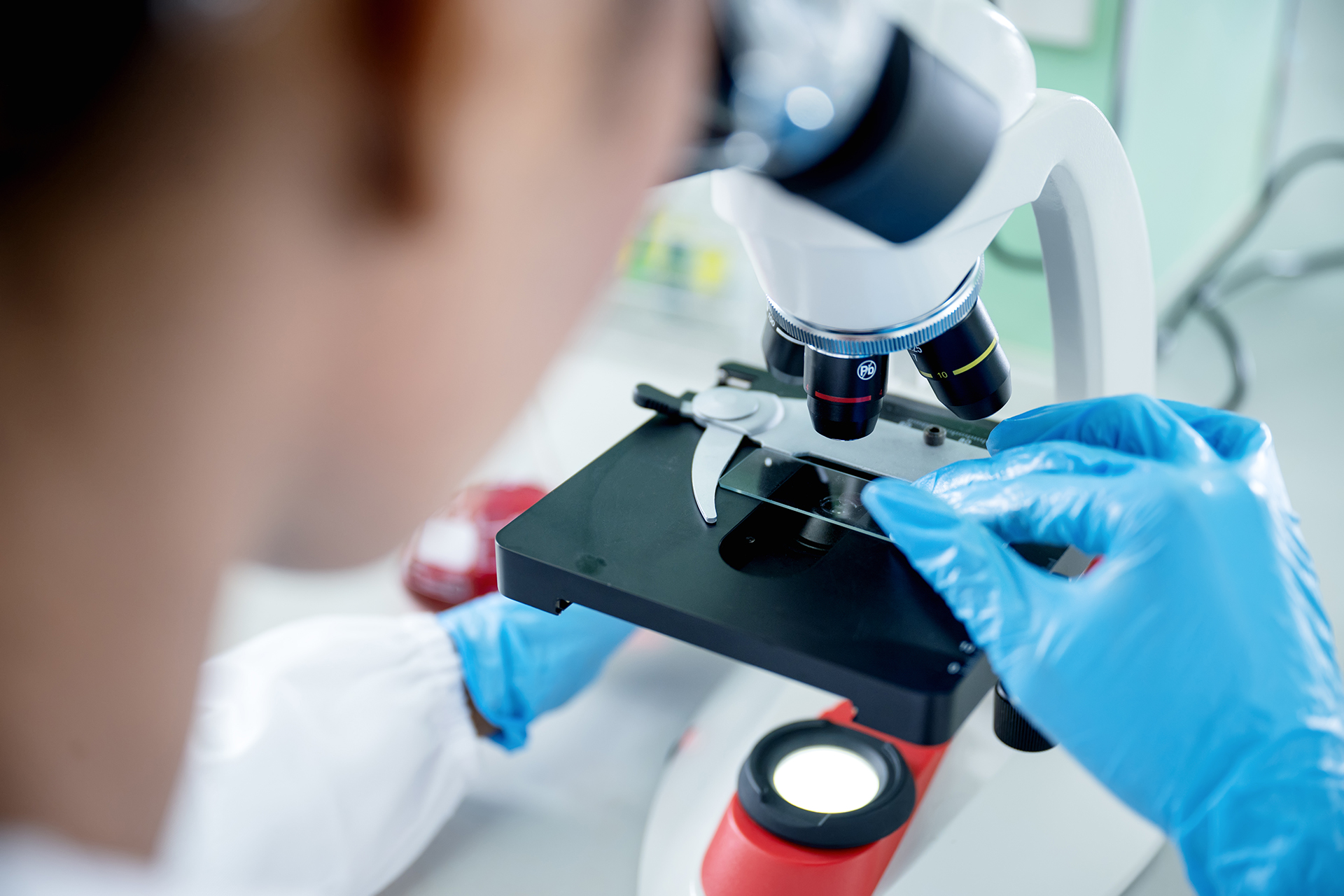 A scientist uses a microscope in a lab.