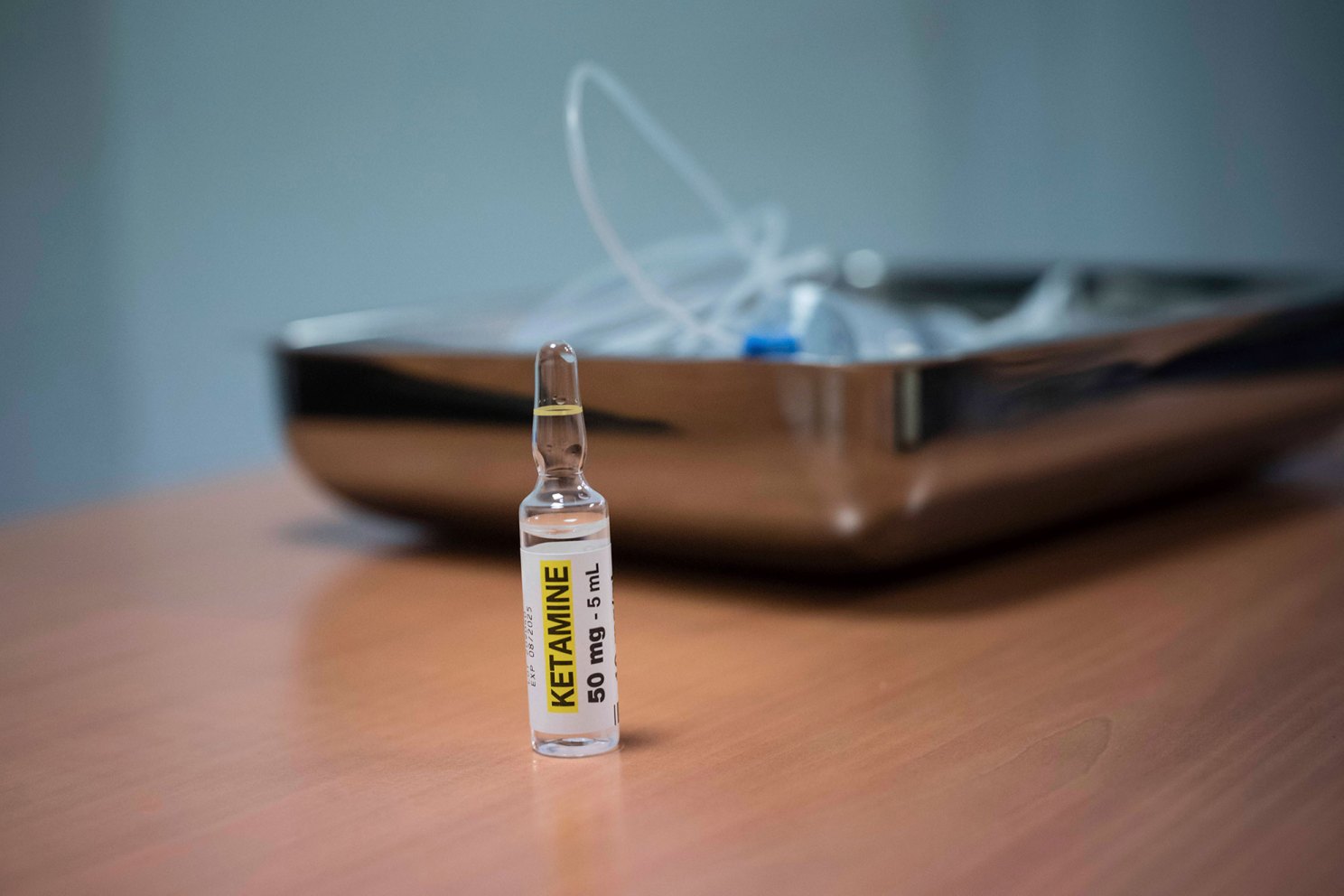 Ketamine in foreground with an IV tube in background.