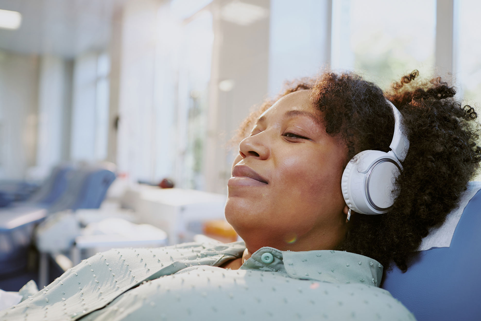 Woman listening to music while waiting for medical treatment.