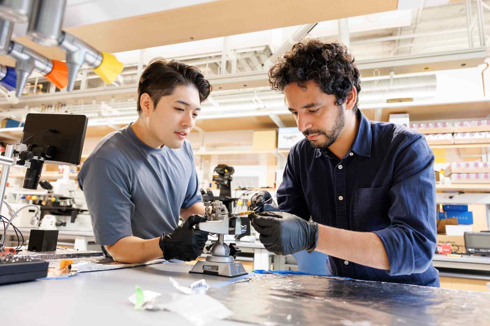 Suk Hyun Sung (left) and Ismail El Baggari working together on an electron microscope specimen holder. 