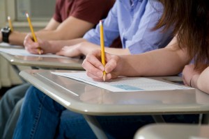 Grade-school students taking exams at their desks.