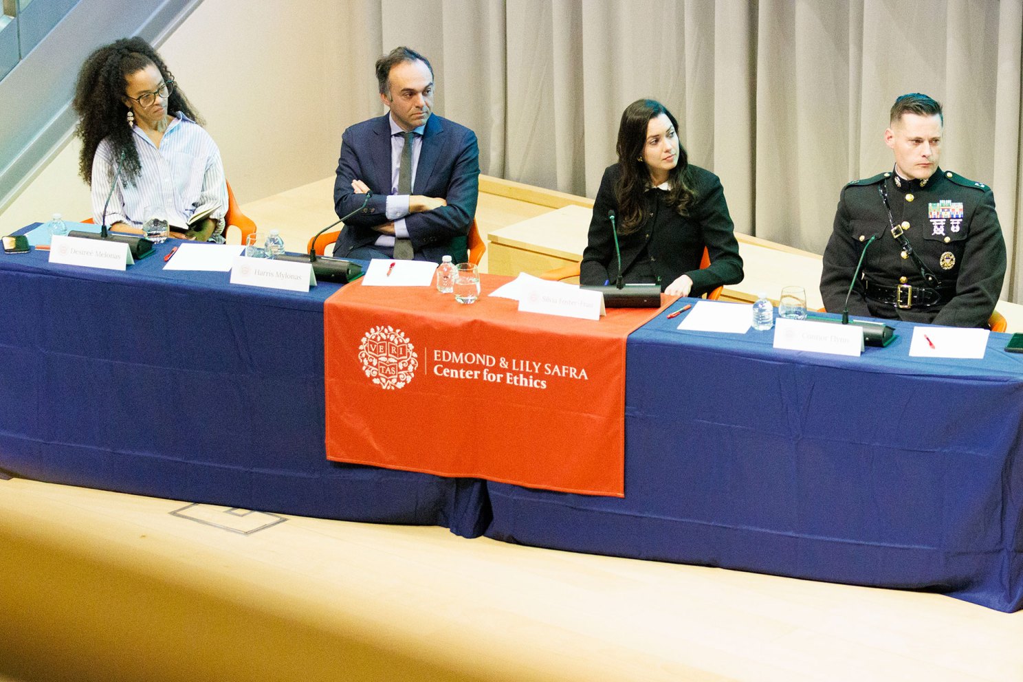 Panelists sit in front of an audience.