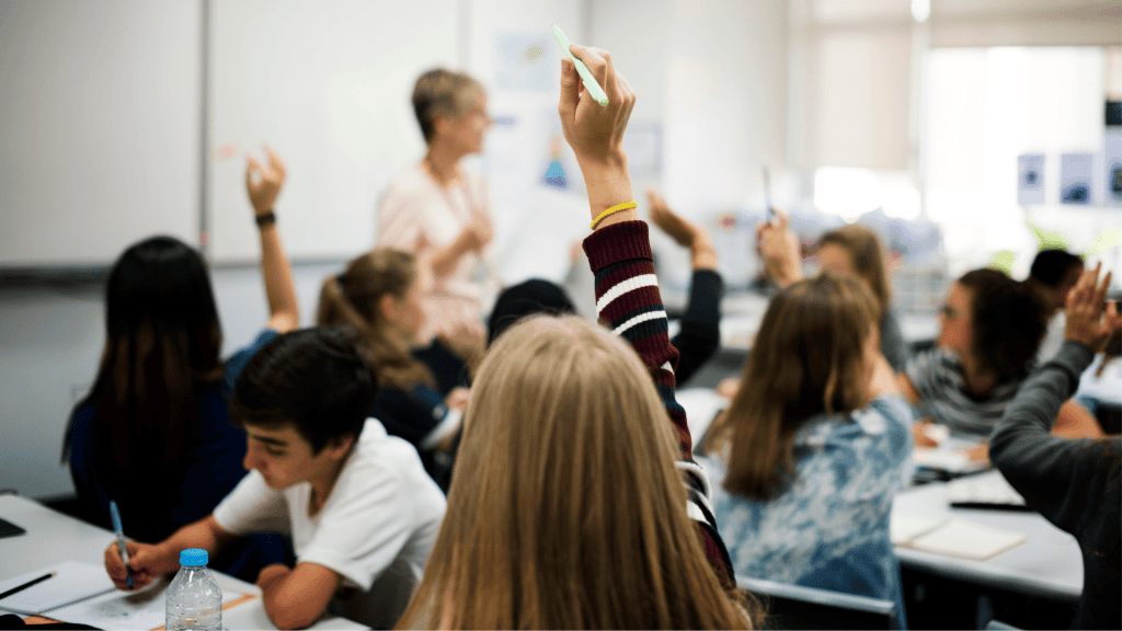 girl raising her hand in a classroom