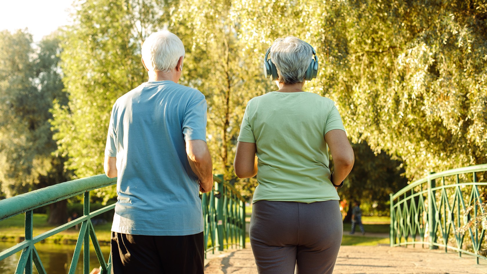 Older adults walk briskly in the park.