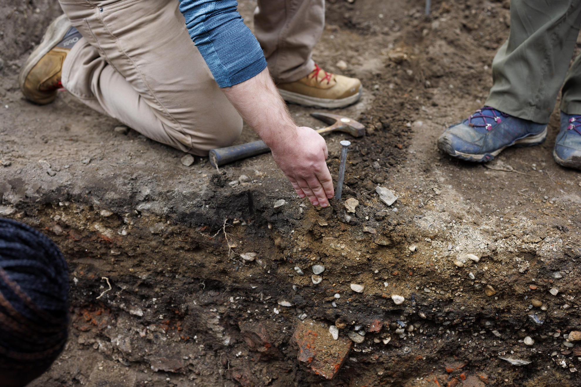 Student David Broussard gestures down toward soil strata.
