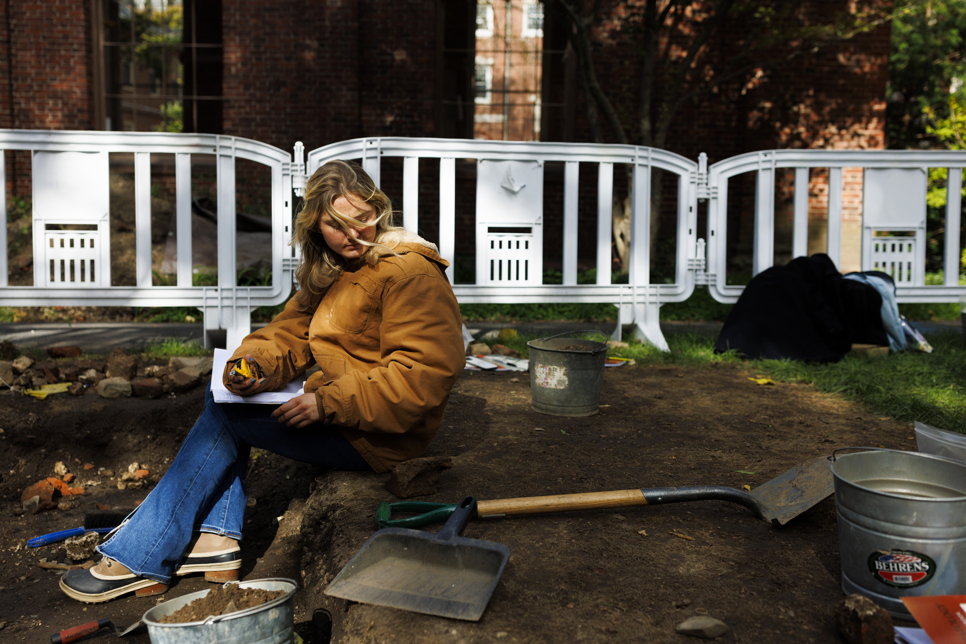 Student Charlotte Hodgson prepares to document a piece of brick discovered.