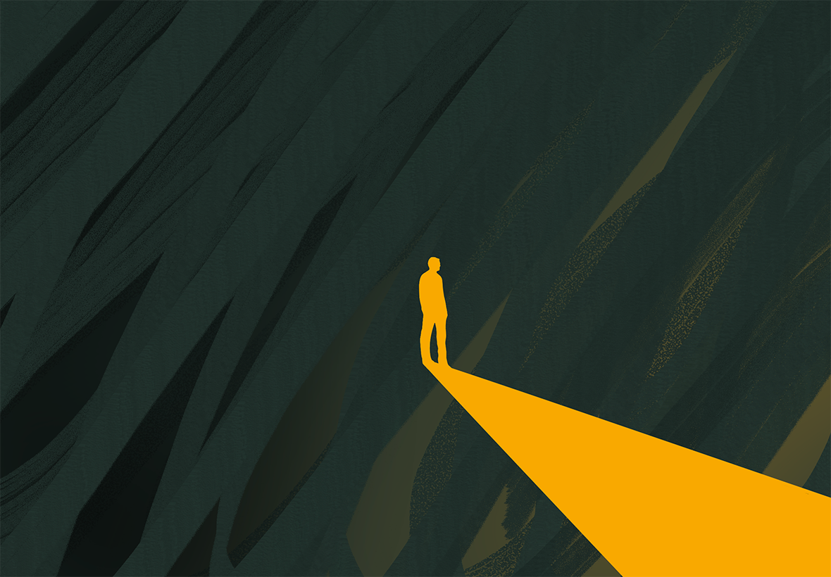 person in the dark walking towards light