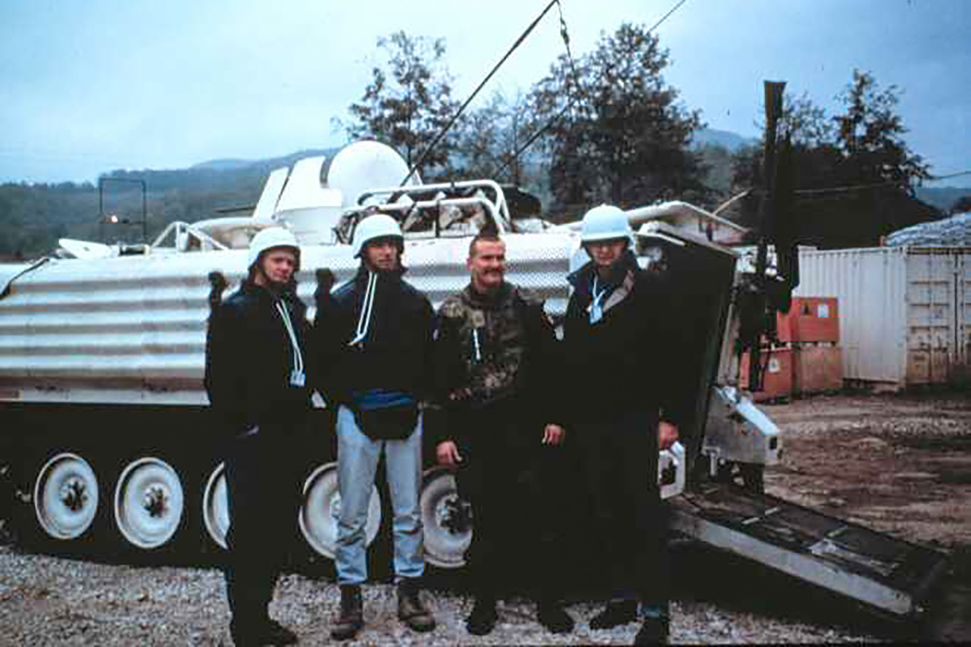 Michael VanRooyen and others next to a tank in Bosnia.