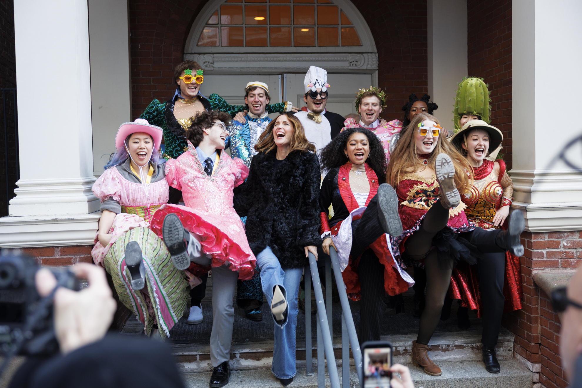 Rose Byrne (center) and members of the Hasty Pudding Theatricals do a kick line together in front of Farkas Hall. V