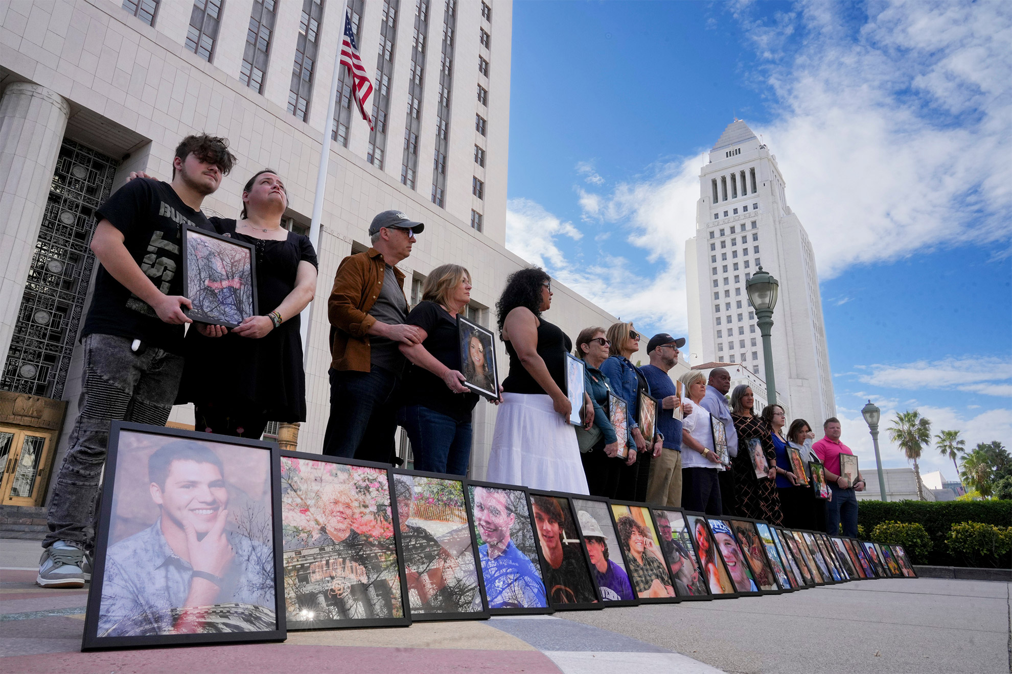 Parents of children who have died due to alleged social media-related harms hold photos of their at the Los Angeles Superior Courthouse.
