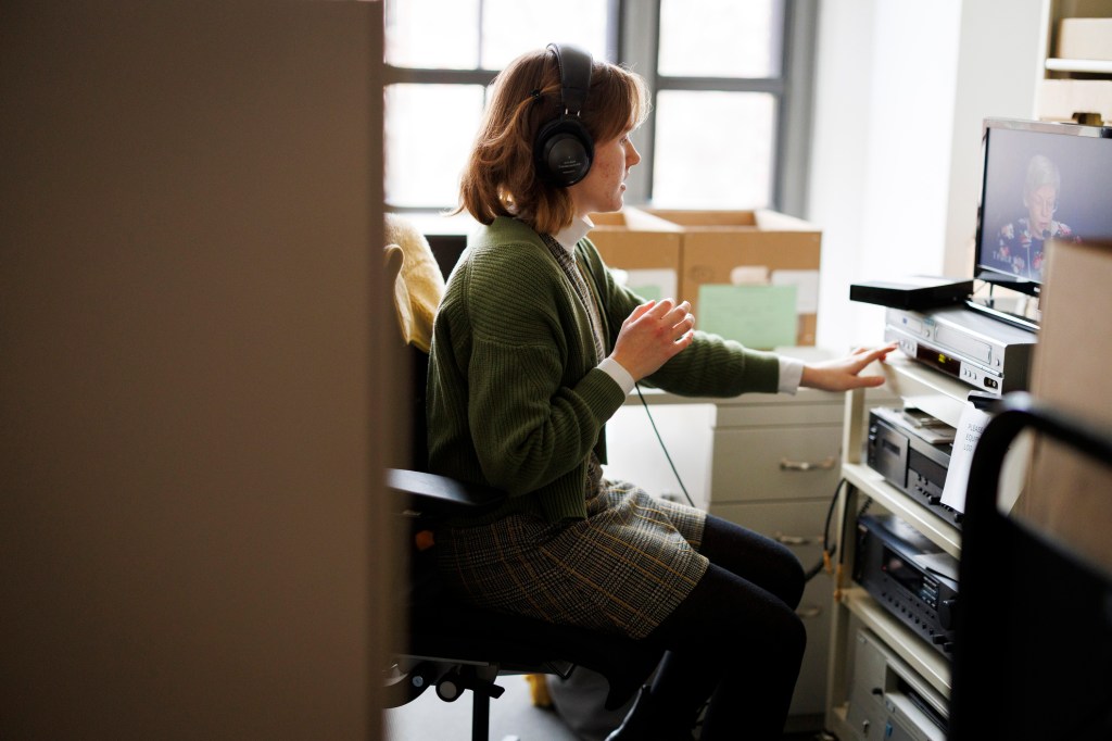 Processing assistant Michaela O'Gara-Pratt reviews VHS tapes.