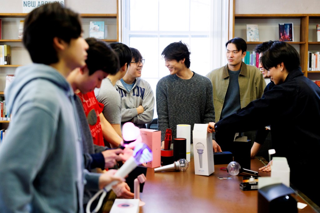 Joshua Lee ’29 (from center left), Andrew Chen ’28, and Kiyeon Cheong ’28 examine K-pop lightsticks.