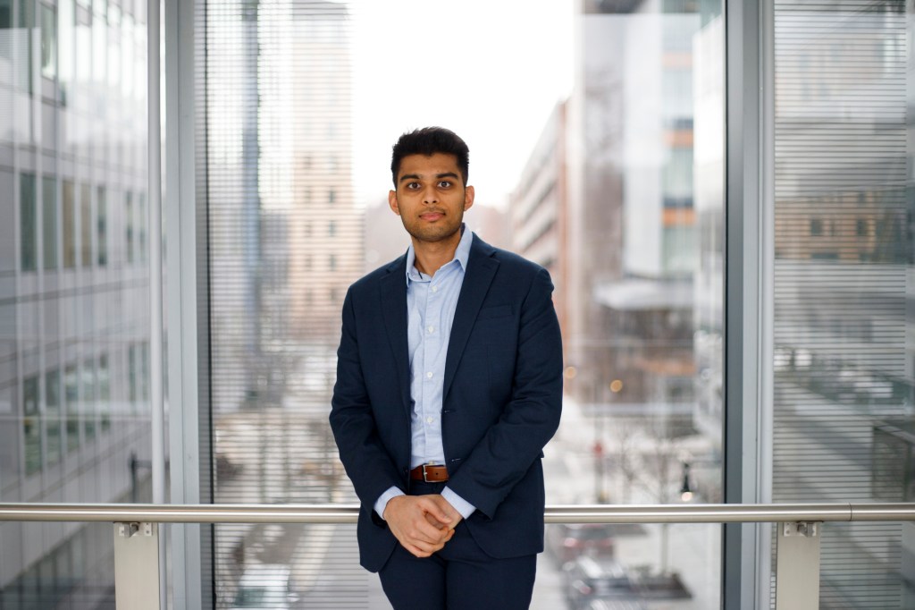 Vishal Patel standing in front of a large window.