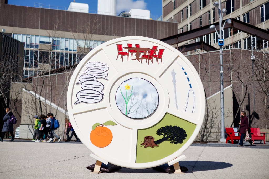 Giant Seder plate sculpture on Harvard's campus with colorful custom images.