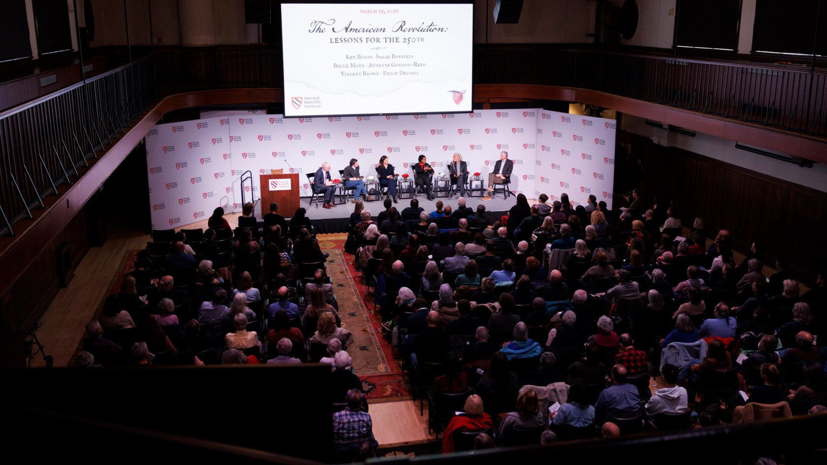 A full audience watching the panelists onstage. at Radcliife's “The American Revolution: Lessons for the 250th”