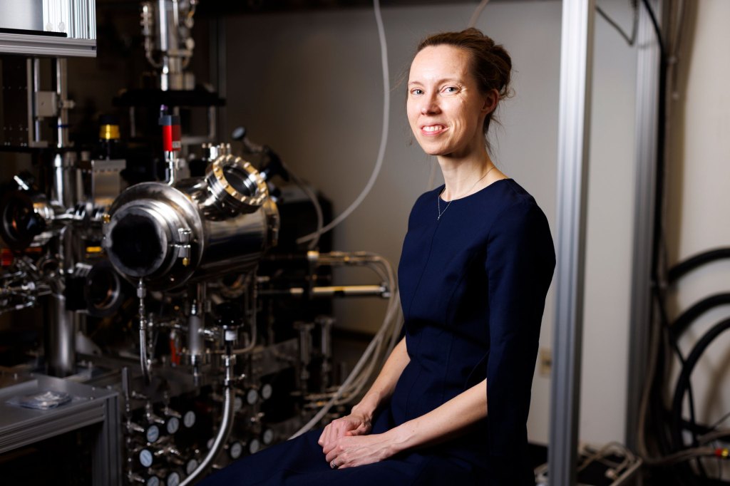 Karin Öberg is seen in a portrait near a vacuum instrument in her lab.