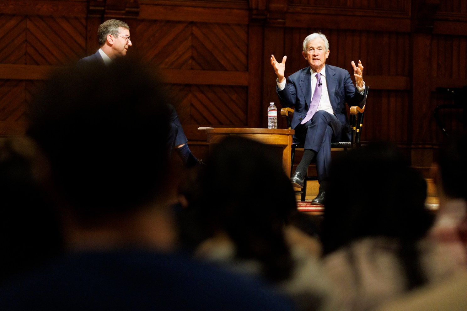 Jerome Powell (right) speaks to a class in Sanders Theatre. He was joined by David Laibson, 