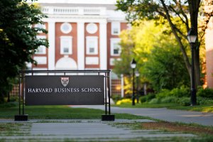 A photo of the sign for Harvard Business School in front of Baker Library.